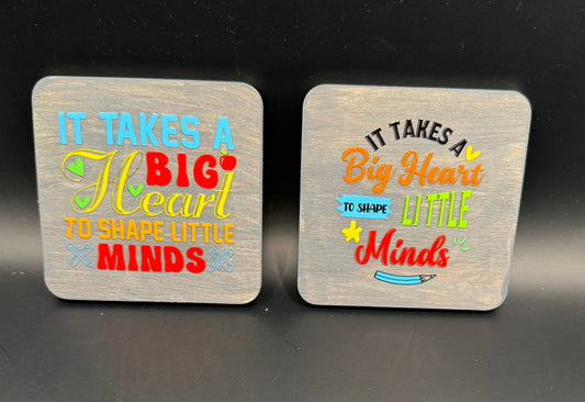 Two coasters with motivational text on a black surface